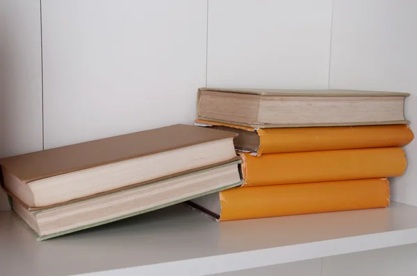 Stos książek książka w twardej oprawie na drewnianej półce. — Zdjęcie stockowe