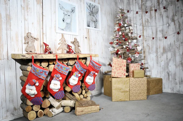 Interior de Navidad con chimenea decorativa, árbol de Navidad y regalos — Foto de Stock