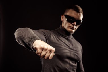 Sağ kroşe yumruk. Yakın çekim, bir yumruk mans. El kasları ve damarlar. Güneş gözlüğü. Stüdyo vurdu. Robocop stili