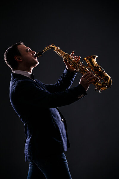 musician plays jazz at saxophone