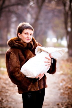 silah, bir battaniyeye sarılmış Holding bebek anne. yumuşak odak etkisi.