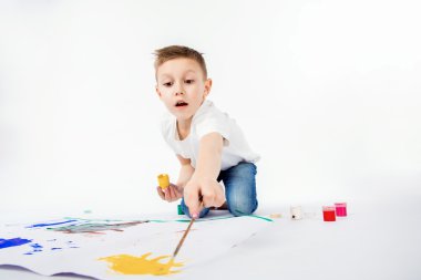 Boya fırçalı çocuk. 9 yıl Boy, modern saç stili, beyaz gömlek, mavi kot boya fırçası izole çiziyor. Studio.