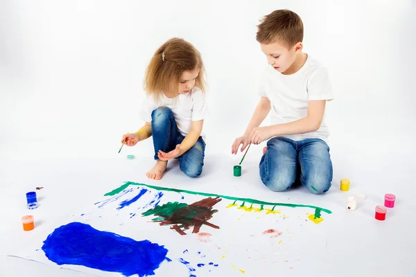 Duas crianças bonitas amigos menino e menina estão desenhando imagens por tintas — Fotografia de Stock