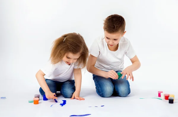 Duas crianças bonitas amigos menino e menina estão desenhando imagens por tintas — Fotografia de Stock