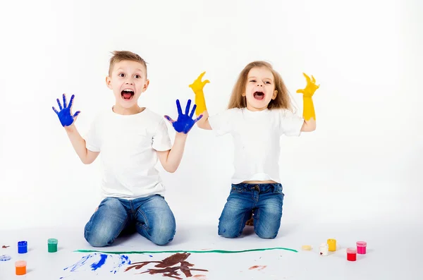 Duas crianças bonitas amigos menino e menina estão desenhando quadros por tintas. Mostrando as mãos em tinta, sckream, rugido, feliz . — Fotografia de Stock