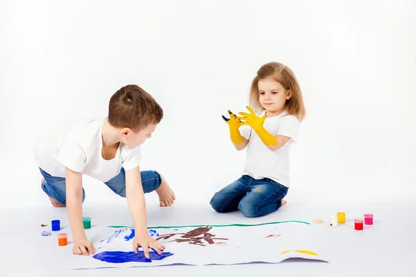 Duas crianças bonitas amigos menino e menina estão desenhando imagens por tintas — Fotografia de Stock