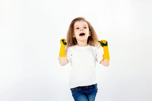 Niña adorable, peinado moderno, camisa blanca, poses vaqueros azules, grito, rugido, sonrisa. Tiene pintura manchada en sus manos. Aislado. Blanco . — Foto de Stock