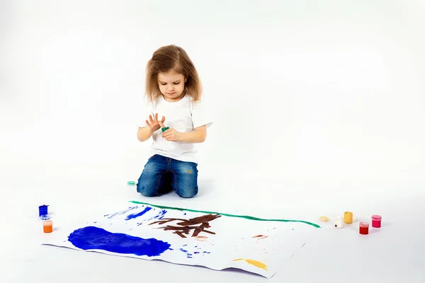 Menina adorável, estilo de cabelo moderno, camisa branca, jeans azul está desenhando imagens por suas mãos com tintas. Isolar . — Fotografia de Stock