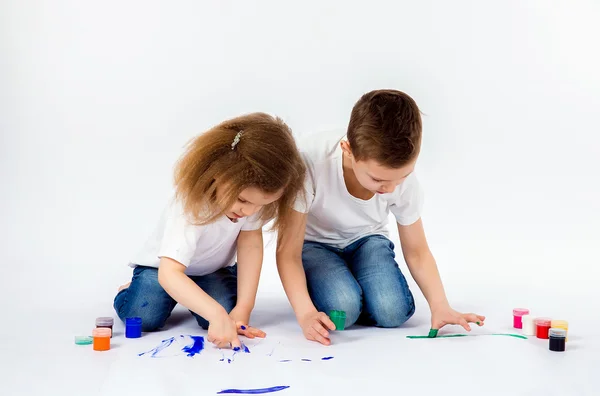 Duas crianças bonitas amigos menino e menina estão desenhando imagens por tintas — Fotografia de Stock