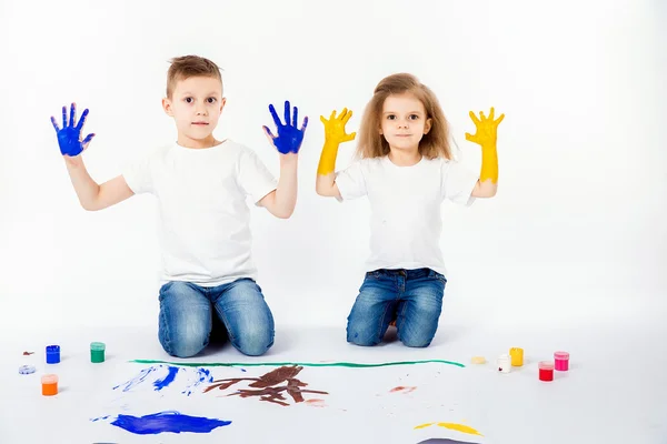 Duas crianças bonitas amigos menino e menina estão desenhando quadros por tintas. Mostrando as mãos em tinta, sckream, rugido, feliz . — Fotografia de Stock