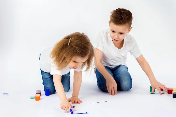 Duas crianças bonitas amigos menino e menina estão desenhando imagens por tintas — Fotografia de Stock