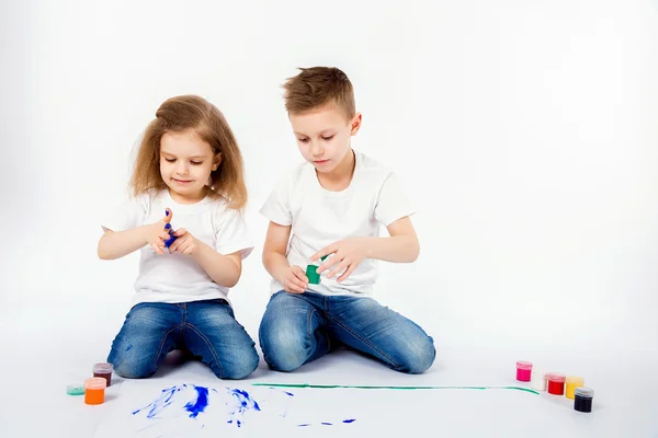 Duas crianças bonitas amigos menino e menina estão desenhando imagens por tintas — Fotografia de Stock