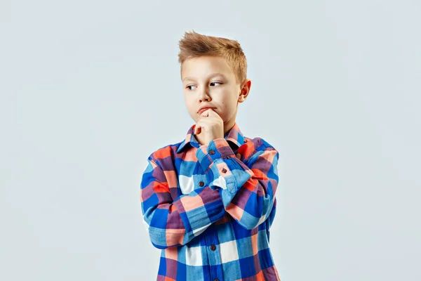 Little boy wearing colorful plaid shirt, plastic glasses thinking, making choose in the studio — Stock Fotó