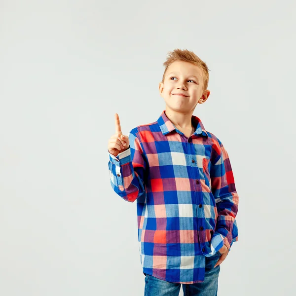 Jongen dragen kleurrijke geruite shirt, blauwe jeans, naar boven geïsoleerd. copyspase. Glimlach. — Stockfoto