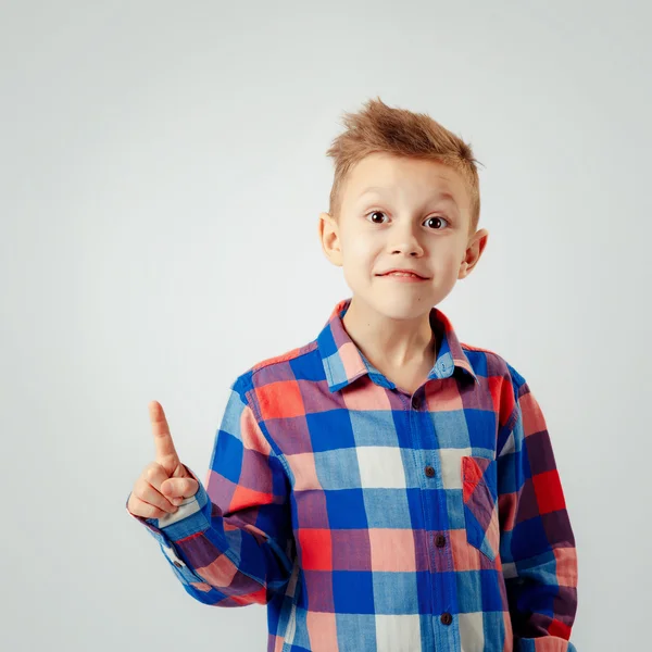 Jongen dragen kleurrijke geruite shirt, wijzend omhoog geïsoleerd. copyspase. Glimlach. — Stockfoto