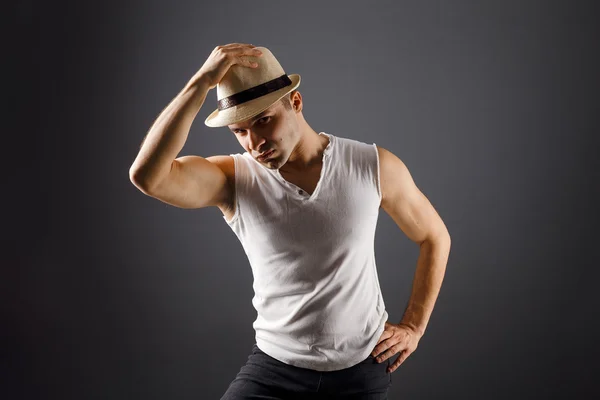 Man fashion model, stylish young man wearing fedora hat standing posing, over black background Stock Photo