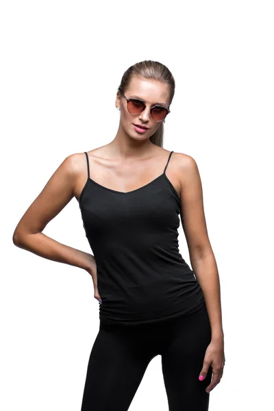 Portré a fiatalok szexuális sportos szőke napszemüveget visel. Elszigetelt fehér. Fekete ing, szűk nadrágok. — Stock Fotó