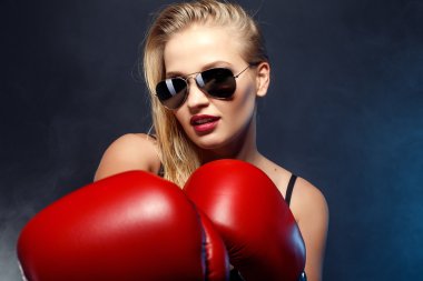 güzel seksi sarışın boksör kız kırmızı eldiven, güneş gözlüğü ve siyah iç çamaşırı giymiş. genç kadın portresi stüdyo.