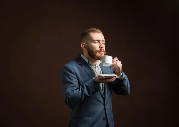 Hombre barbudo guapo disfrutando del olor del café — Foto de Stock
