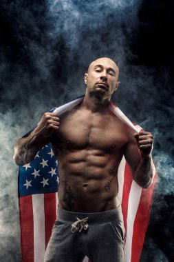 Handsome bald topless man with American flag on shoulders