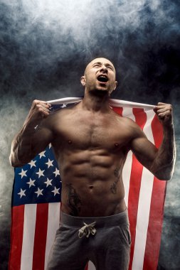 Handsome bald topless man with American flag on shoulders