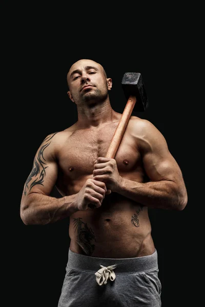 Retrato de atleta sin camisa tatuado con martillo en el hombro — Foto de Stock