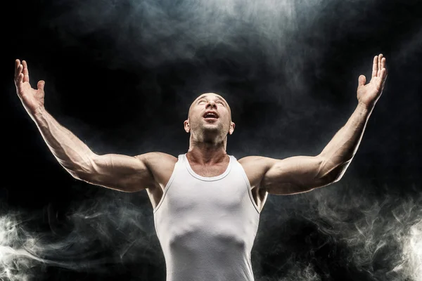 Deportista muscular con los brazos levantados mirando hacia arriba — Foto de Stock