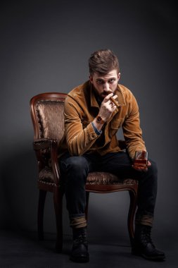 Puro ve viski ile ciddi sakallı adam portresi