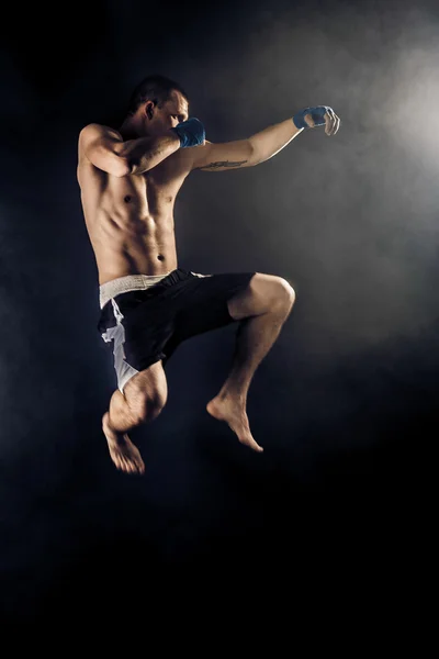 Muscular kickbox ou muay thai lutador perfurando no salto. Fumar . — Fotografia de Stock