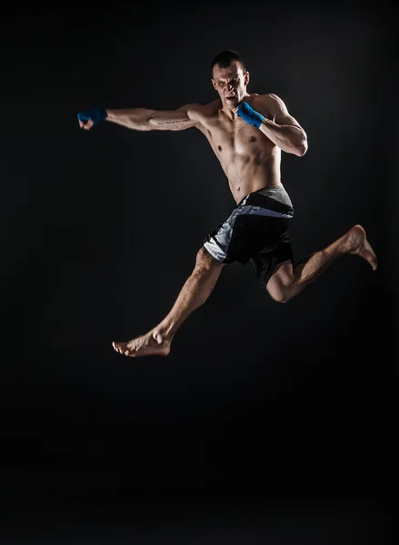 Muscular kickbox ou muay thai lutador perfurando no salto. Fumar . — Fotografia de Stock