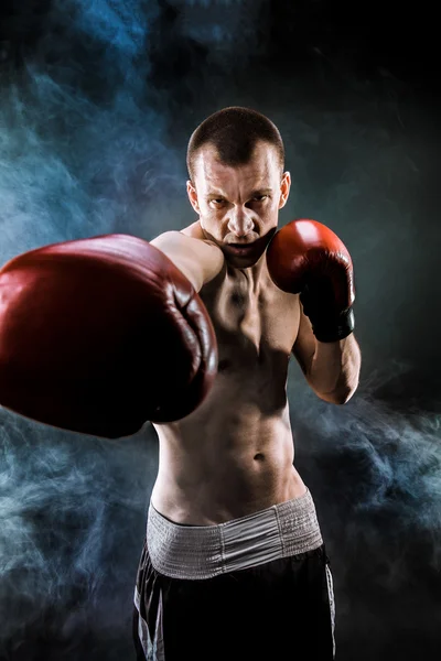 Muscular kickbox ou muay thai lutador perfurando na fumaça . — Fotografia de Stock