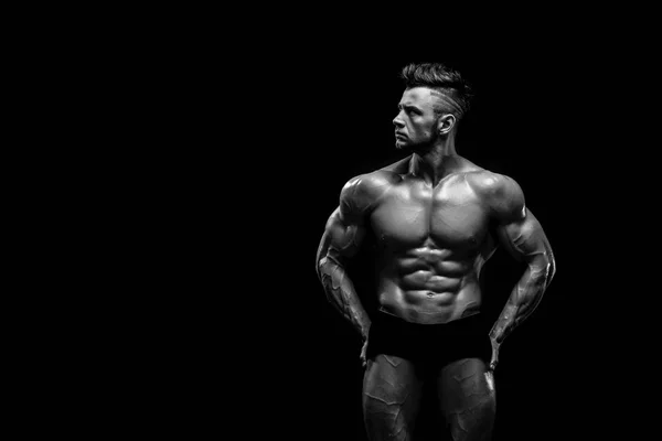 Handsome male model posing at studio in front of a black background. — Stock Photo, Image