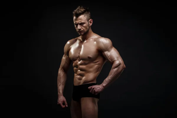 Guapo modelo masculino posando en el estudio delante de un fondo negro. — Foto de Stock