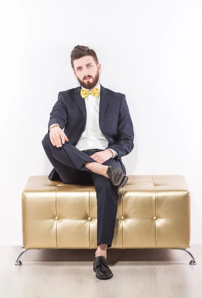 Elegante jovem homem bonito em terno clássico preto com laço amarelo — Fotografia de Stock
