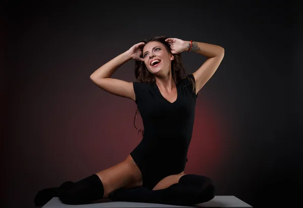Hermosa mujer alegre en cuerpo negro posando con los brazos levantados —  Fotos de Stock