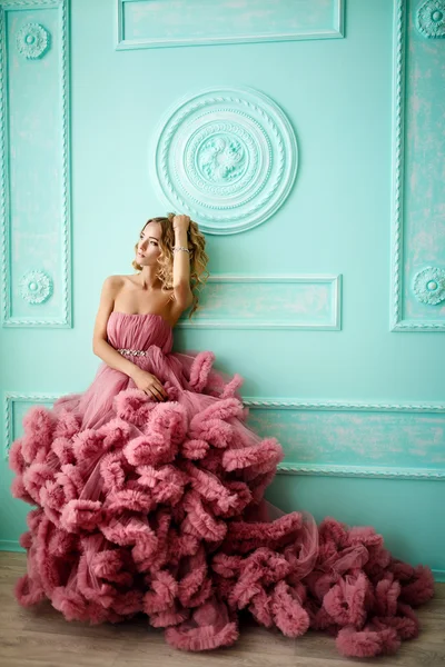 La hermosa mujer con el pelo rubio, rizado, maquillaje tierno posando en un vestido de novia . — Foto de Stock