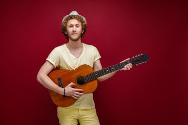 Gitar çalmak şapkalı kıvırcık saçlı adam