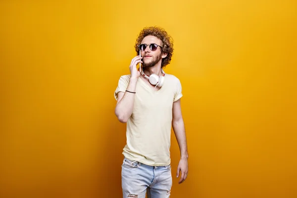 Hombre de pelo rizado en gafas de sol usando la célula — Foto de Stock