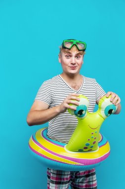 Adam tur mavi arka plan kameraya bakarak bir salyangoz şeklinde Yüzme sualtı maskesi, çizgili gömlekli olan. Tatil kavramı