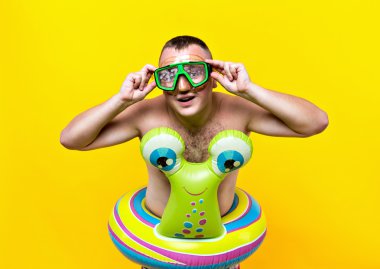 Tur sarı arka plan kameraya bakarak bir salyangoz şeklinde Yüzme sualtı maskesi, çıplak adam. Tatil kavramı