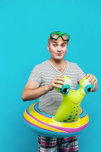 Adam tur mavi arka plan kameraya bakarak bir salyangoz şeklinde Yüzme sualtı maskesi, çizgili gömlekli olan. Tatil kavramı