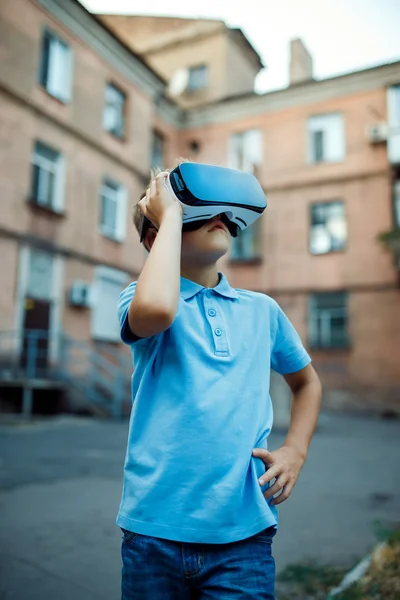 Menino fascinado usando óculos de realidade virtual VR. exterior — Fotografia de Stock