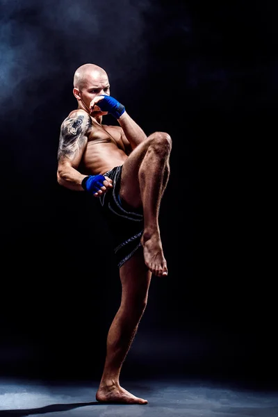 Muscular kickbox ou muay thai lutador perfurando na escuridão — Fotografia de Stock