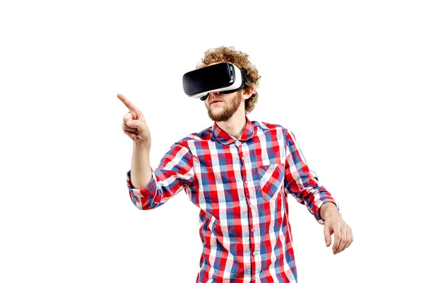 Joven hombre de pelo rizado con camisa a cuadros usando un auricular VR y experimentando realidad virtual aislado sobre fondo blanco — Foto de Stock