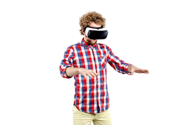 Joven hombre de pelo rizado con camisa a cuadros usando un auricular VR y experimentando realidad virtual aislado sobre fondo blanco —  Fotos de Stock