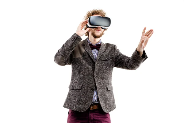 Un joven hombre de negocios de pelo rizado con traje marrón usa un auricular VR y experimenta realidad virtual aislada sobre fondo blanco — Foto de Stock