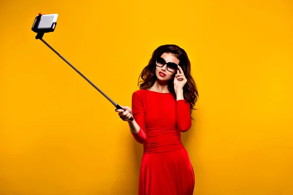 Brunette selfie maken in zonnebrillen en rode jurk — Stockfoto