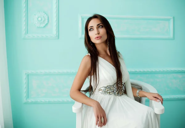 Mujer sensual en vestido blanco en sillón —  Fotos de Stock