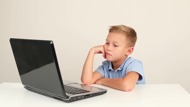 Bonito teen menino trabalhando no laptop computador ou assistindo vídeo no internet — Vídeo de Stock