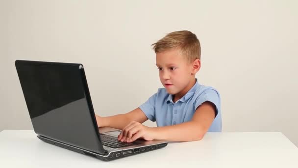 Söt teen pojke arbetar på bärbar dator eller titta på video på internet — Stockvideo